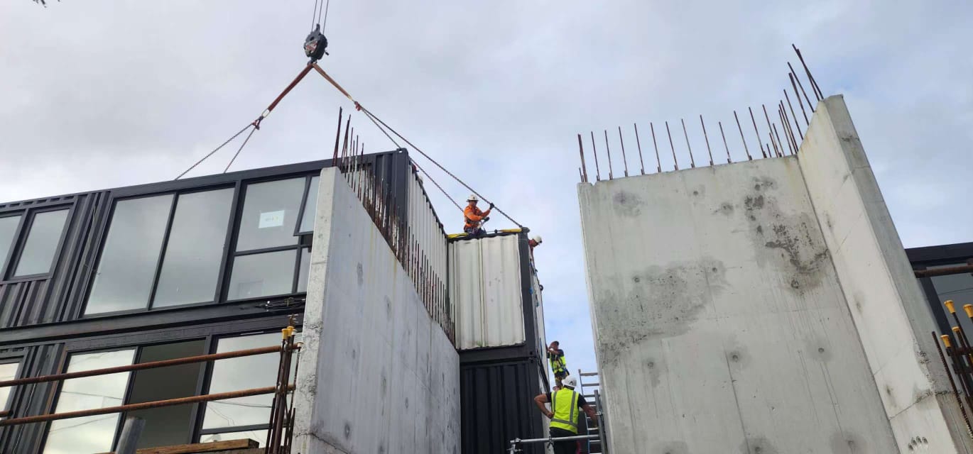 Steel framed modular building craned between concrete core walls on site during building surveyor inspection for a building permit in Australia